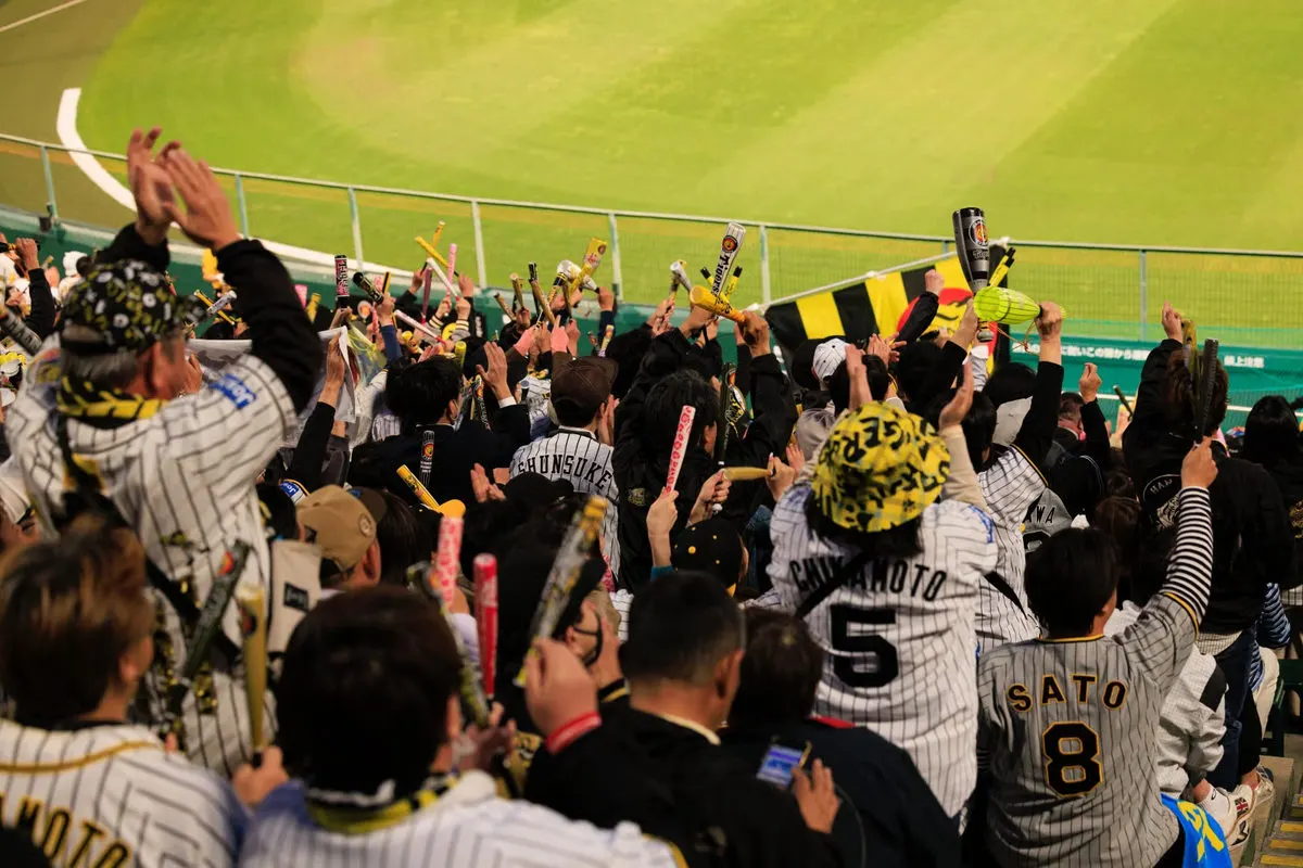 Hanshin Tigers fans cheering with megaphones in the stands at Koshien Stadium