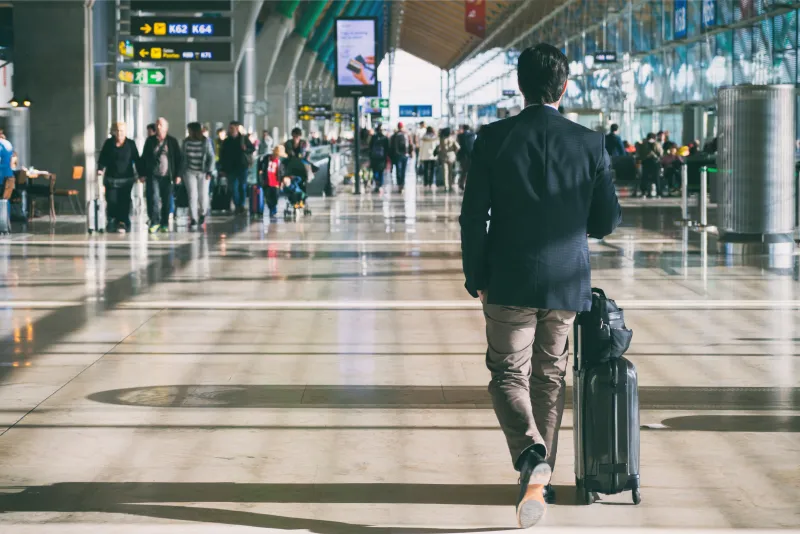 Business traveller walking through an airport with a suitcase