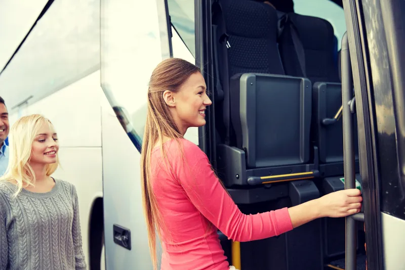 Group travellers boarding a tour bus
