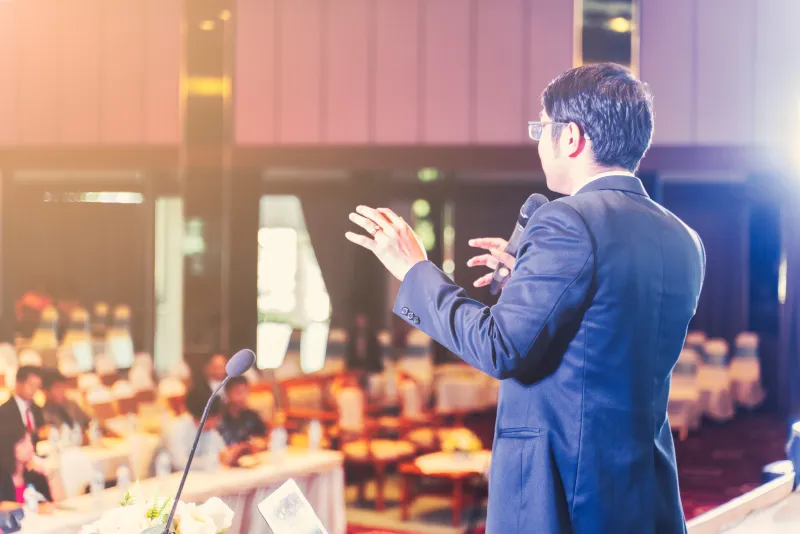 Speaker presenting on stage at a conference