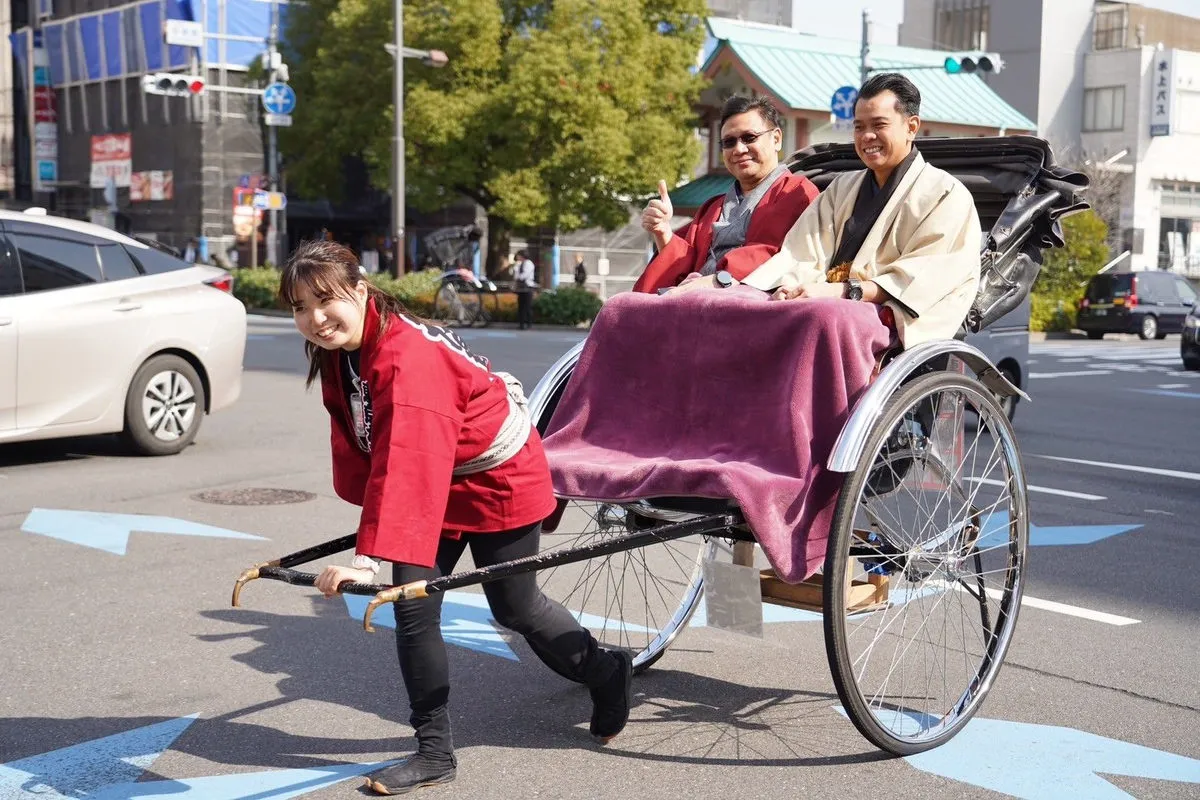 Travellers riding a rickshaw along a street in Asakusa